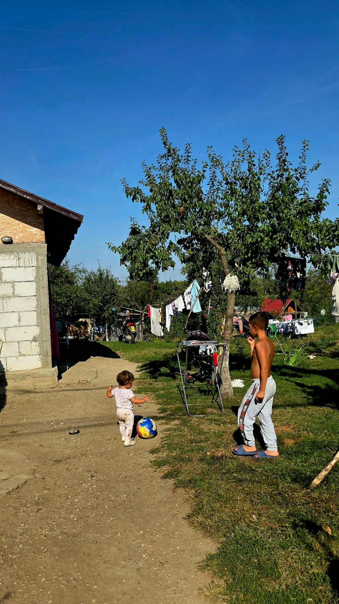 Copiii unei familii sprijinite, în curtea casei