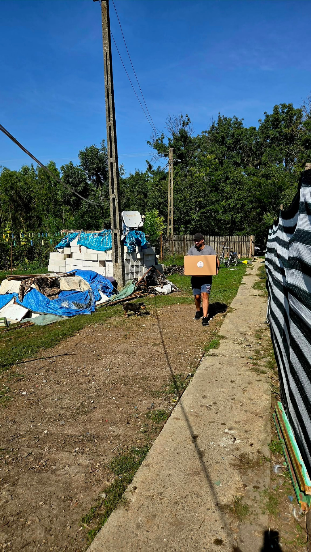 Voluntar pe drum spre casa unei familii, cu pachetul lunar