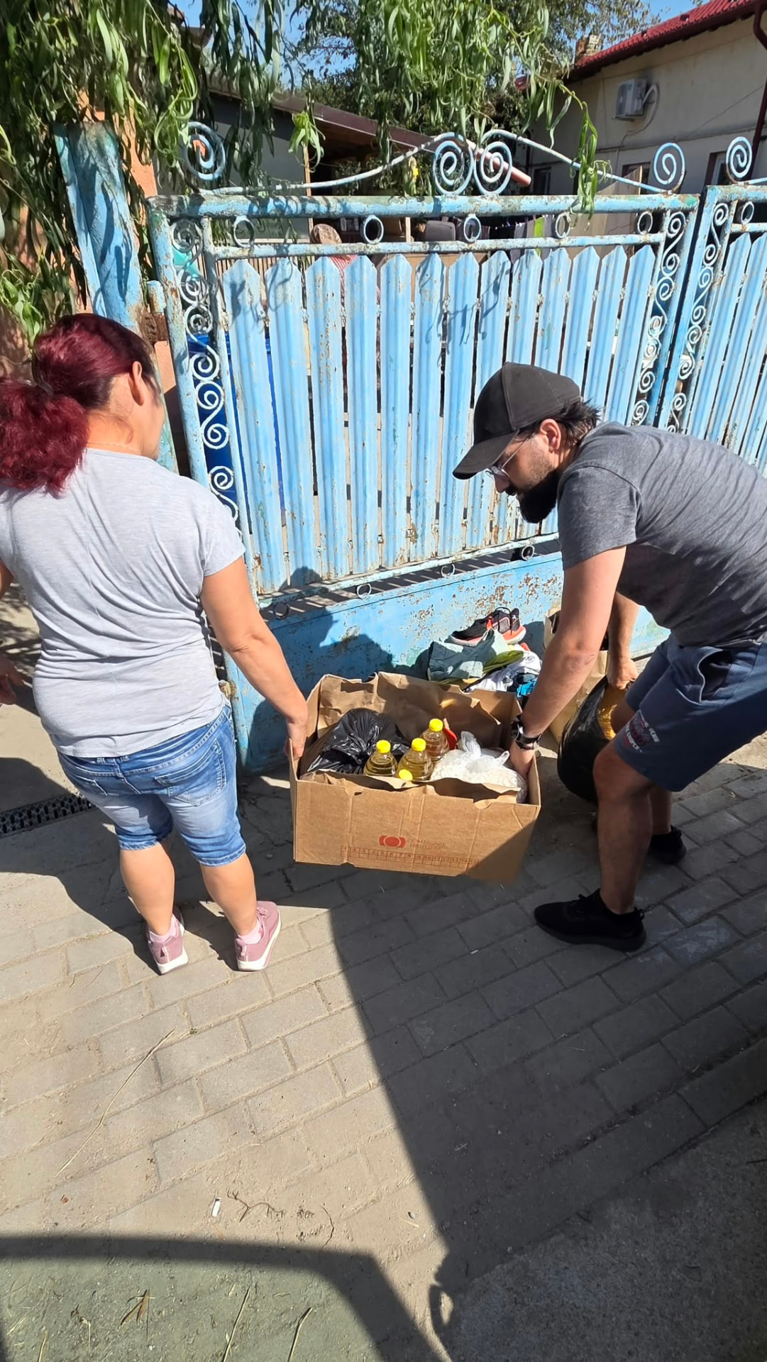 Voluntarul predă pachetul lunar unei familii sprijinite